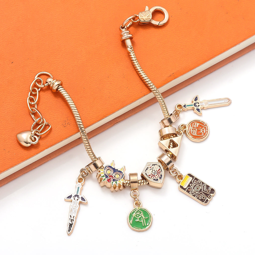 Legend of Zelda Charm Bracelet in silver with colorful enamel by MokshaGoldSculptures on orange and white background.