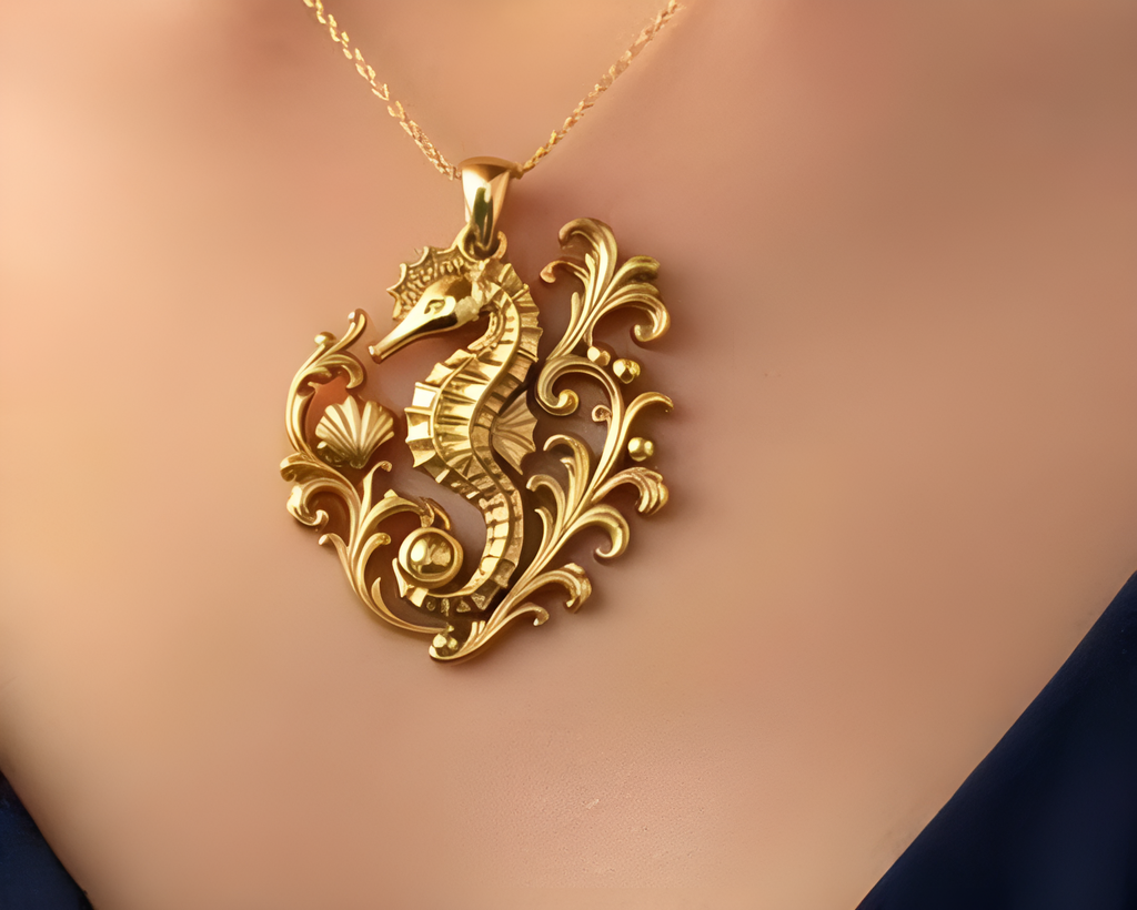 Seahorse Pendant Necklace in gold by MokshaGoldSculptures, ornate marine details, shown over a dark blue garment.