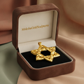 The Interwoven Star of David Pendant Necklace in rustic 18K gold by MokshaGoldSculptures in a brown and white box.