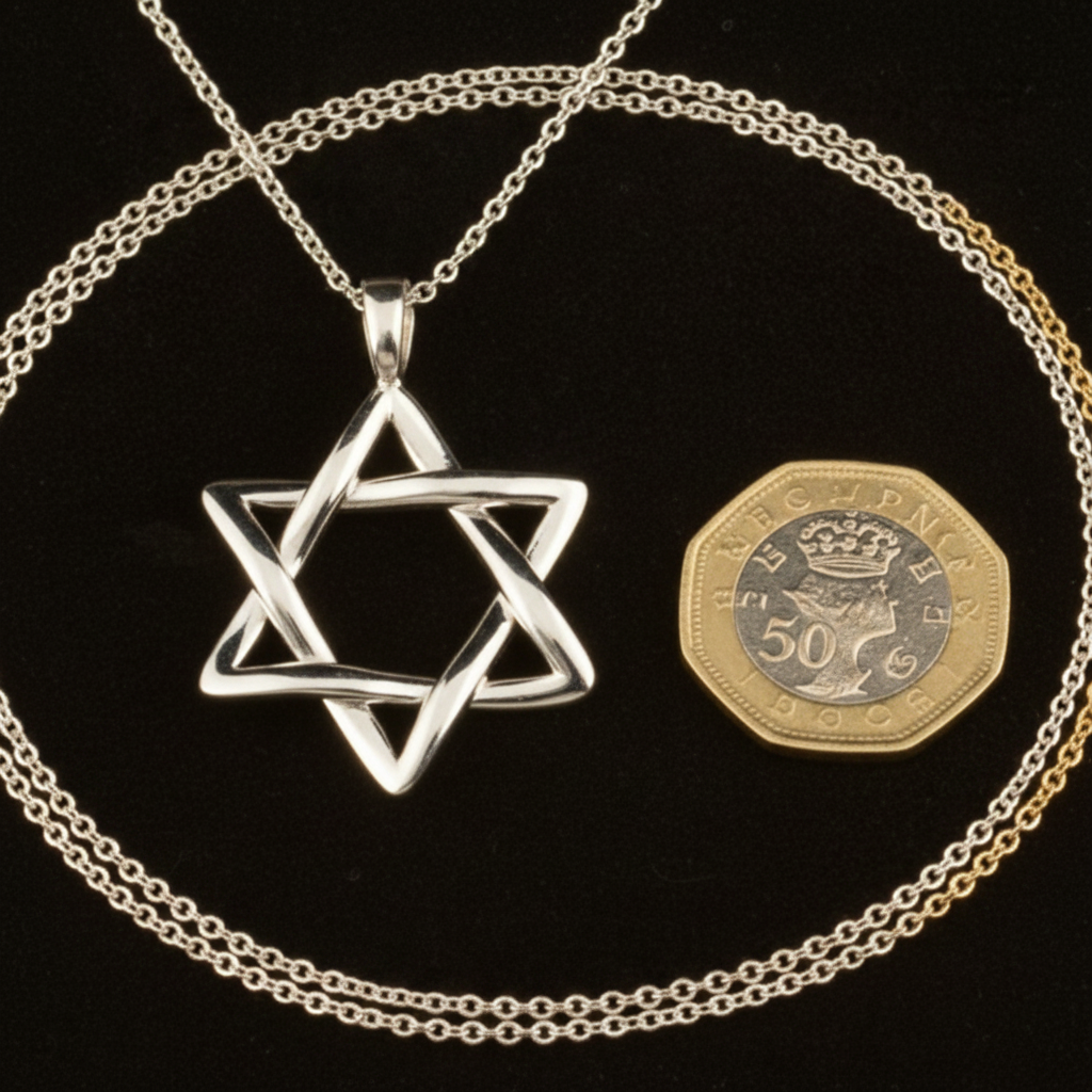 The Interlaced Star of David Pendant Necklace in 18K gold by MokshaGoldSculptures, shown with a 50p coin for scale.