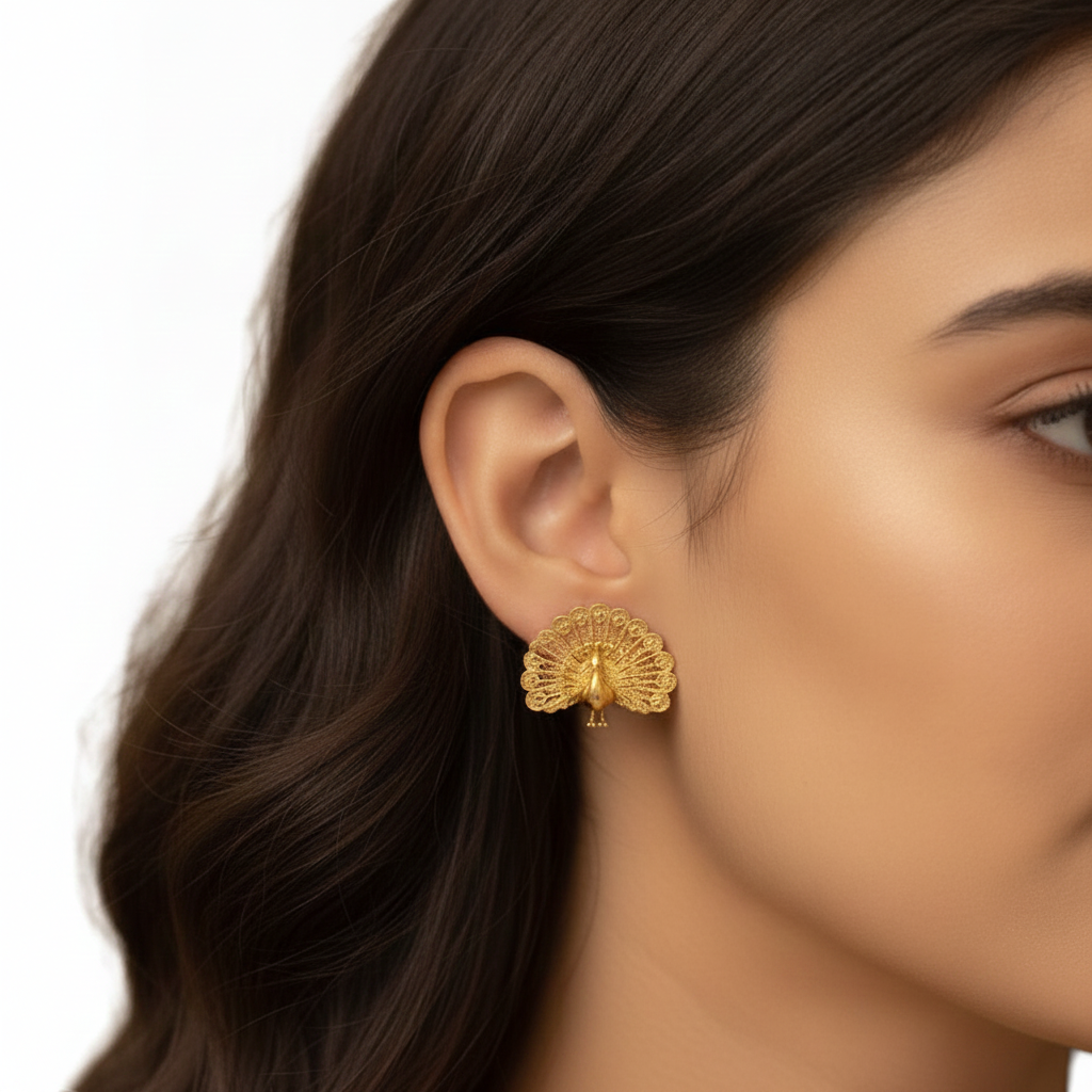 Peacock Stud Earrings in 9K gold, sterling silver, or polished brass by MokshaGoldSculptures worn by a woman.