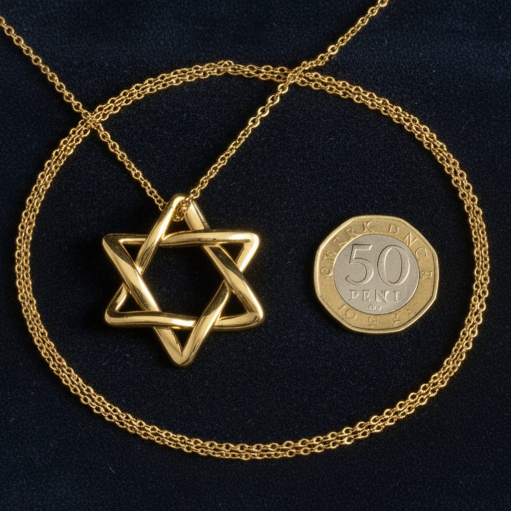 The Interlaced Star of David Pendant Necklace in 18K gold by MokshaGoldSculptures, shown with a 50 pence coin for scale.