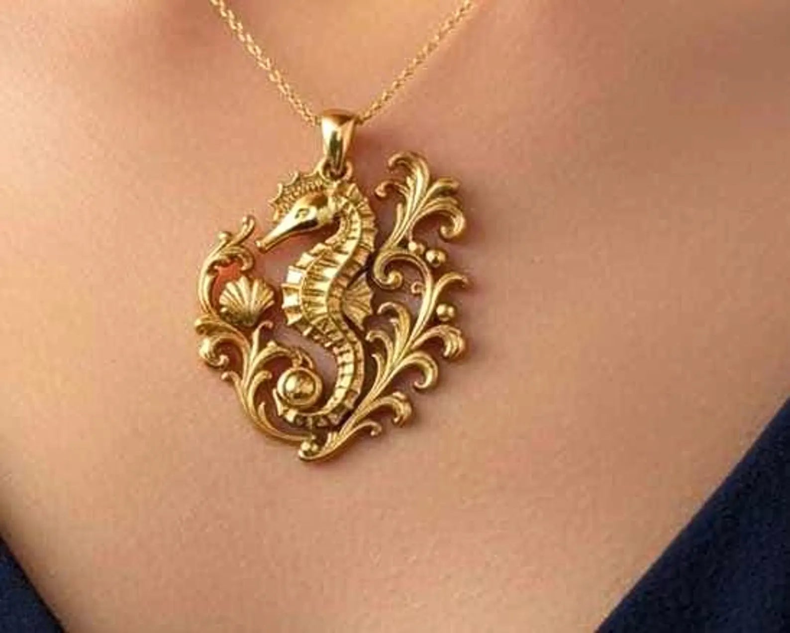 The Seahorse Pendant Necklace in gold finish by MokshaGoldSculptures, ornate ocean swirl design.