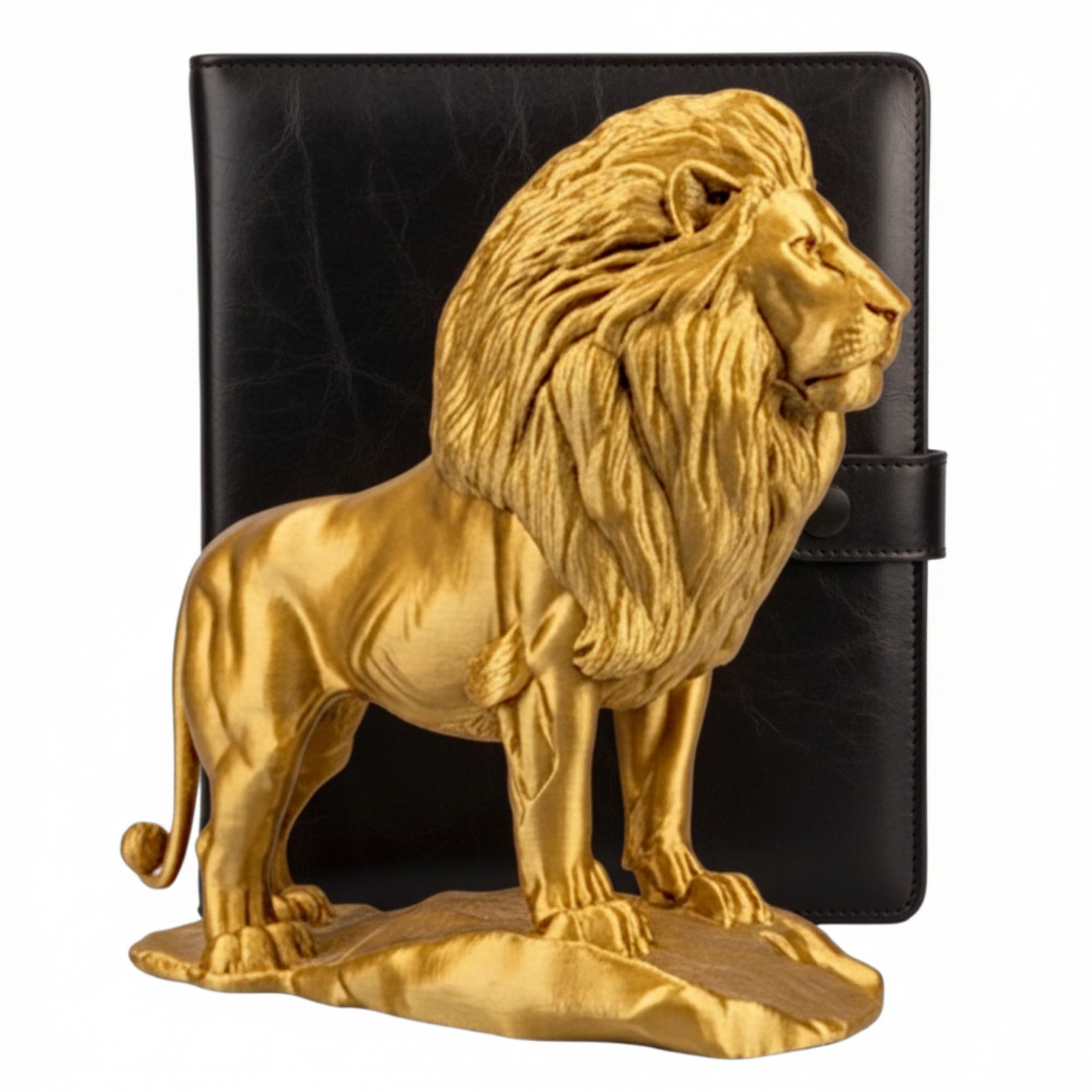 The Gold Lion Statue on Rock, metallic finish by MokshaGoldSculptures, 3D printed desk decor shown with black notebook.